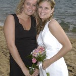 The bride with her maid of honor on the beach