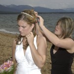 One of the bridesmaids helps the bride fix her hair