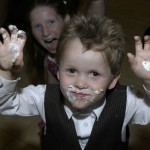 Ring bearer boy eats cake at reception