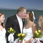 The bride and groom have their first kiss while their children watch