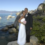 The married couple pose on a rock in Lake Tahoe