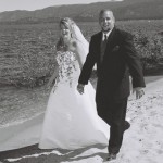 Newlyweds walk hand in hand along the beach