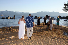 Father of the bride escorts his daughter down the sandy aisle