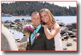 Newlyweds hug by the rocks at the cove