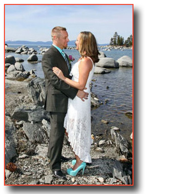 Bride and groom pose by the rocks at the shoreline